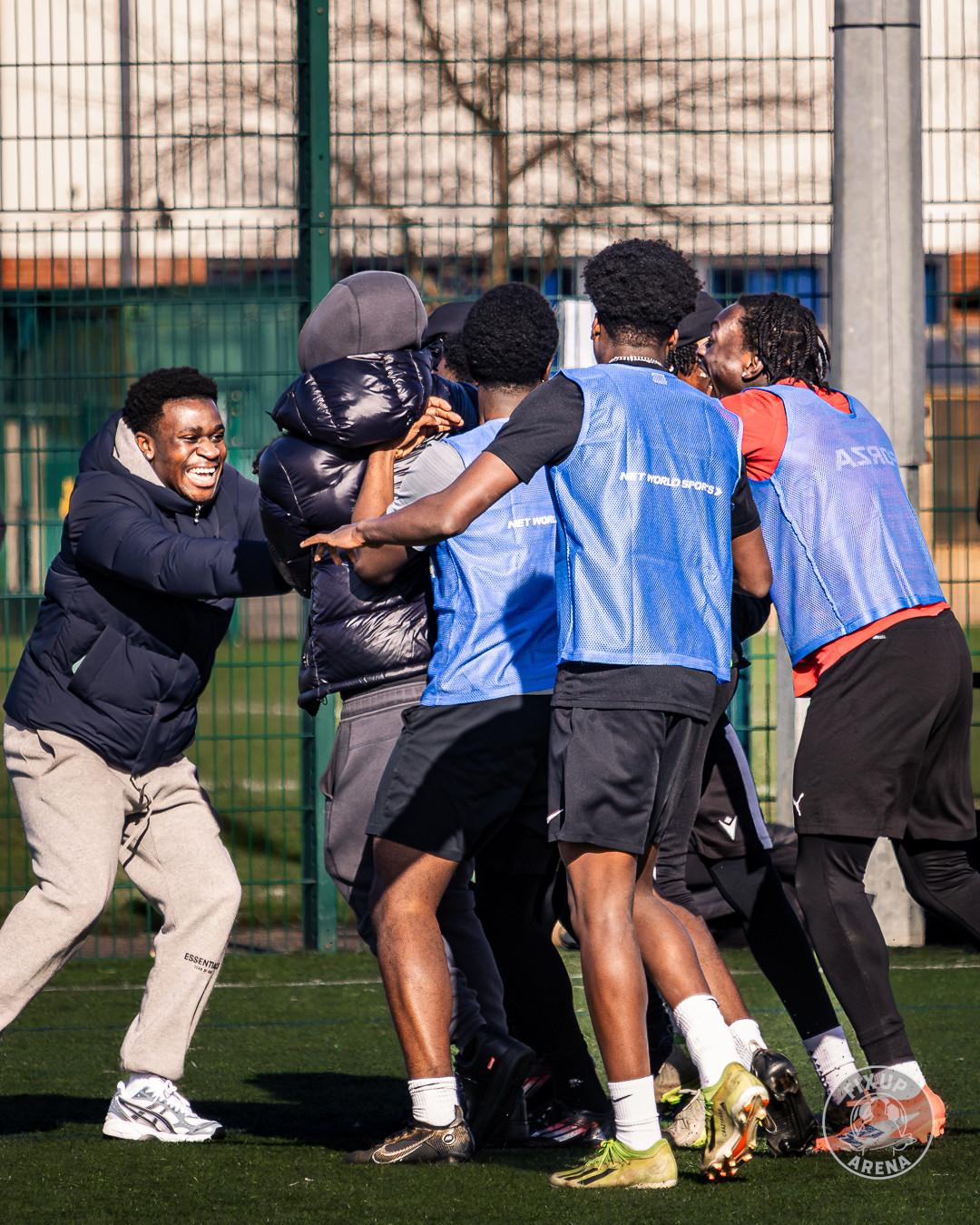 Players celebrating together on the pitch at the first FixUp Arena tournament